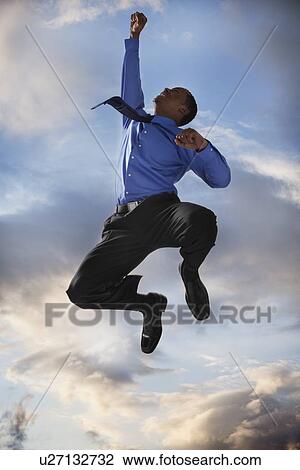 Stock Image - Excited businessman jumping. Fotosearch