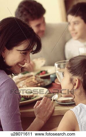 Stock Image - Family eating a meal together. Fotosearch