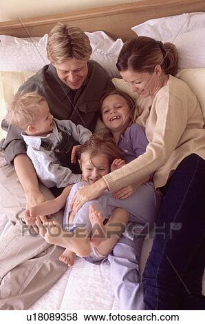 Family playing on bed together View Large Photo Image Stock Photo - Family playing on bed together. Fotosearch
