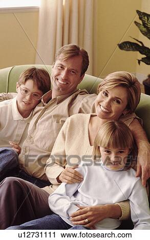Stock Image - Family relaxing on couch together. Fotosearch