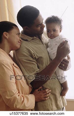 Stock Photography - Father and mother with their baby. Fotosearch