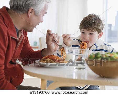 Father and son eating spaghetti View Large Photo Image Stock Photograph - Father and son eating spaghetti. Fotosearch