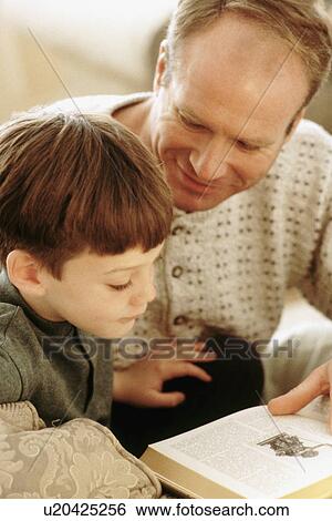 Stock Photograph - Father and son reading together. Fotosearch
