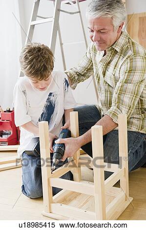 Stock Photography - Father and son repairing stool. Fotosearch