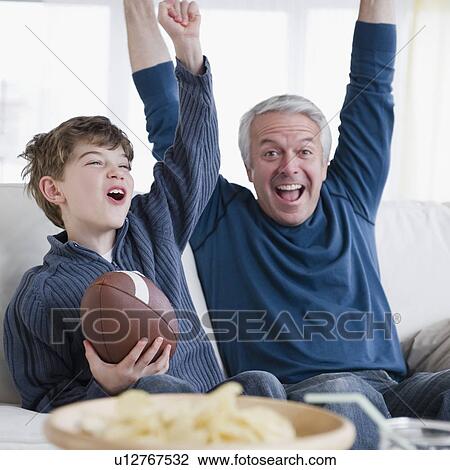Father and son watching football game View Large Photo Image Stock Image - Father and son watching football game. Fotosearch