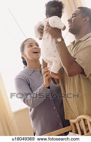 Stock Photo - Father picking up his baby. Fotosearch