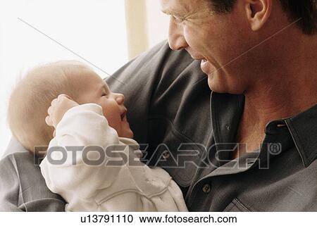 Father smiling at his baby View Large Photo Image Stock Image - Father smiling at his baby. Fotosearch