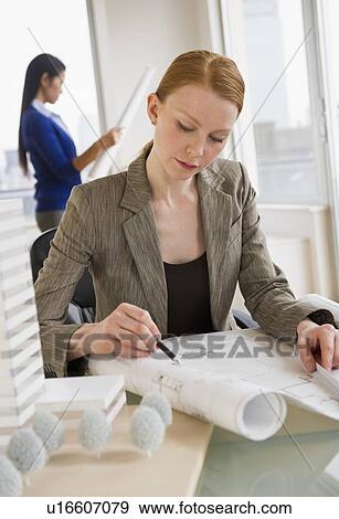 Female architect looking at blueprints View Large Photo Image Stock Photo - Female architect looking at blueprints. Fotosearch