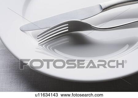Fork and knife on empty white plate View Large Photo Image Stock Image - Fork and knife on empty white plate. Fotosearch