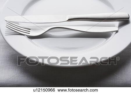 Fork and knife on empty white plate View Large Photo Image Stock Photograph - Fork and knife on empty white plate. Fotosearch