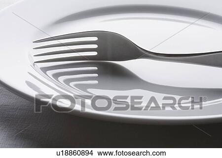 Picture - Fork on empty white plate. Fotosearch