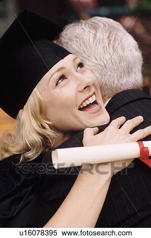 Graduate embracing her father View Large Photo Image Stock Photography - Graduate embracing her father. Fotosearch