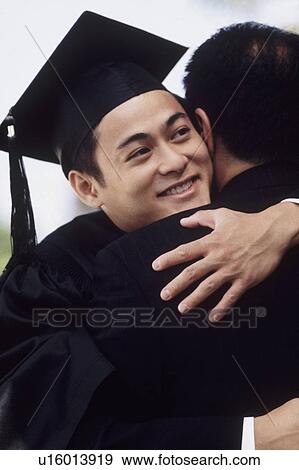 Graduate embracing his father View Large Photo Image Stock Photo - Graduate embracing his father. Fotosearch
