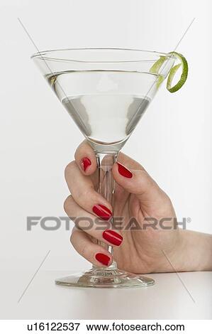 Stock Photo - Hand holding martini glass. Fotosearch