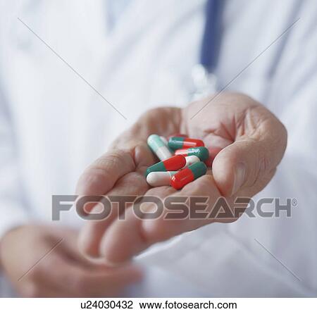 Stock Image - Hand holding prescription pills. Fotosearch
