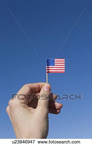 Hand holding small American flag View Large Photo Image Stock Photo - Hand holding small American flag. Fotosearch