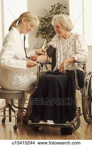 Picture - Healthcare worker checking an elderly woman's blood pressure. Fotosearch
