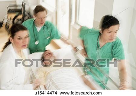 Healthcare workers pushing gurney in emergency room View Large Photo Image Picture - Healthcare workers pushing gurney in emergency room. Fotosearch