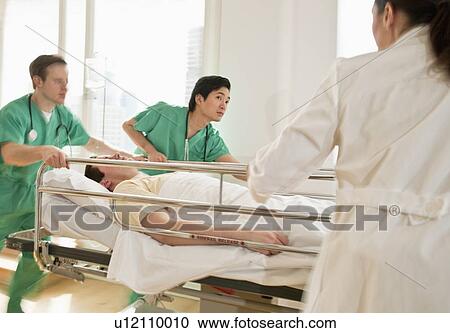 Healthcare workers pushing gurney in emergency room View Large Photo Image Stock Image - Healthcare workers pushing gurney in emergency room. Fotosearch