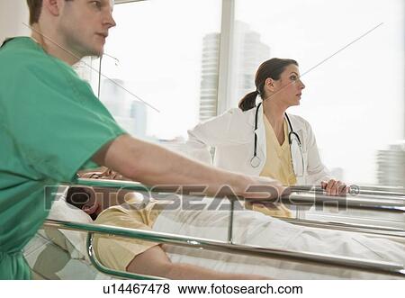 Healthcare workers pushing gurney in emergency room View Large Photo Image Stock Photo - Healthcare workers pushing gurney in emergency room. Fotosearch