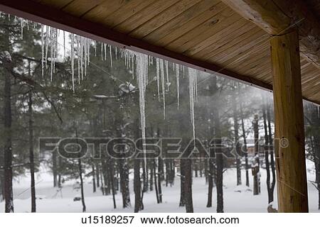 Stock Photo - Icicles on log cabin. Fotosearch