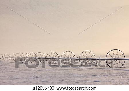 Stock Photo - Irrigation equipment on a snow covered field. Fotosearch