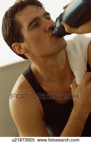 Stock Photography - Man drinking water after exercising. Fotosearch