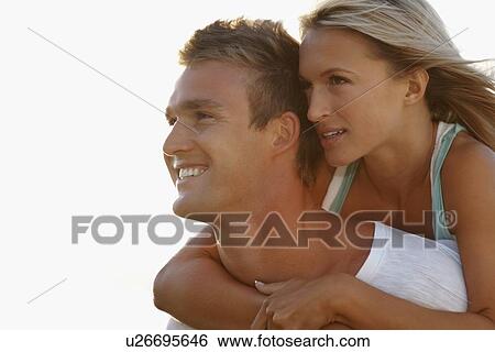Stock Photograph - Man giving girlfriend a piggy back ride. Fotosearch