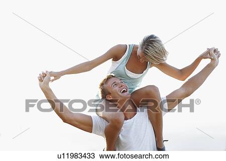 Man giving girlfriend a shoulder ride View Large Photo Image Stock Image - Man giving girlfriend a shoulder ride. Fotosearch