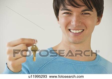 Stock Image - Man holding key. Fotosearch