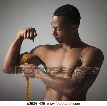 Stock Photograph - Man measuring his triceps. Fotosearch