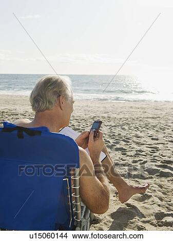 Man relaxing in beach chair View Large Photo Image Picture - Man relaxing in beach chair. Fotosearch