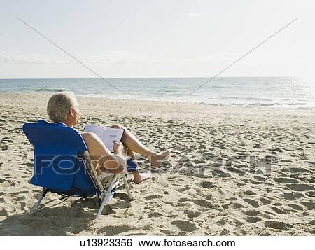 Stock Photograph - Man relaxing in beach chair. Fotosearch