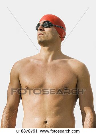 Stock Image - Man wearing bathing cap and swimming goggles. Fotosearch