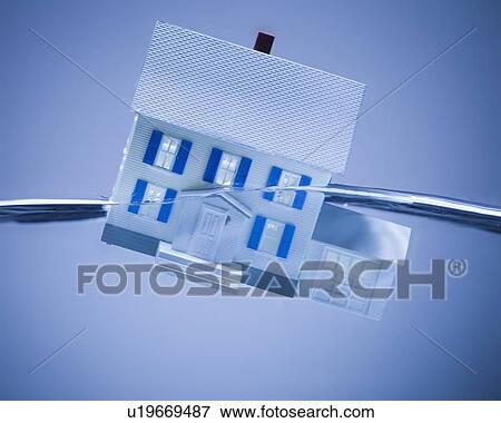 Model home sinking in water View Large Photo Image Stock Photo - Model home sinking in water. Fotosearch