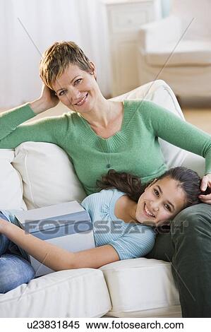 Stock Photography - Mother and daughter relaxing on couch. Fotosearch