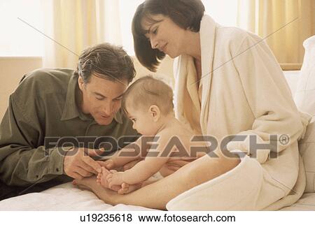 Mother and father admiring their newborn baby View Large Photo Image Stock Photo - Mother and father admiring their newborn baby. Fotosearch