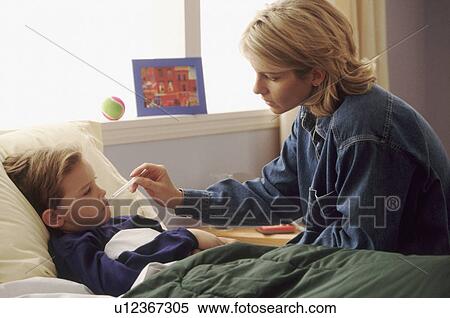 Stock Photography - Mother checking son's temperature. Fotosearch