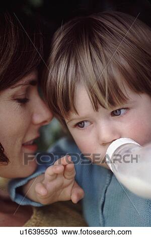 Stock Image - Mother giving her child a bottle. Fotosearch