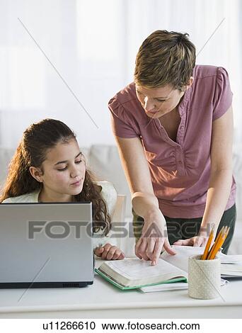 Stock Image - Mother helping daughter with her homework. Fotosearch
