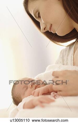 Stock Image - Mother holding her newborn baby. Fotosearch