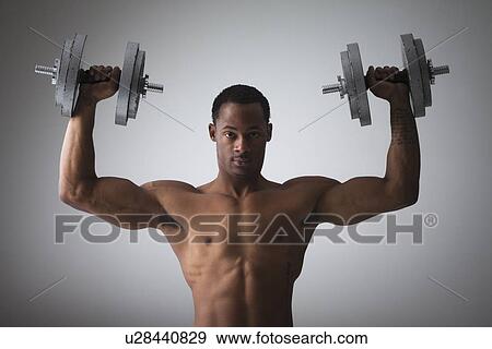 Muscular man lifting dumbbells View Large Photo Image Stock Photo - Muscular man lifting dumbbells. Fotosearch