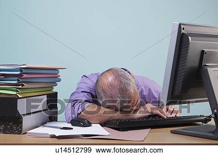 Overworked man sleeping at his desk View Large Photo Image Stock Photo - Overworked man sleeping at his desk. Fotosearch