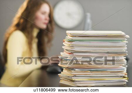 Stock Photo - Overworked woman in cubicle. Fotosearch
