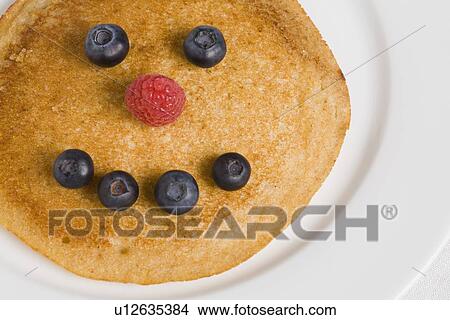 Pancake with smiley face made from blueberries and raspberry View Large Photo Image Picture - Pancake with smiley face made from blueberries and raspberry. Fotosearch