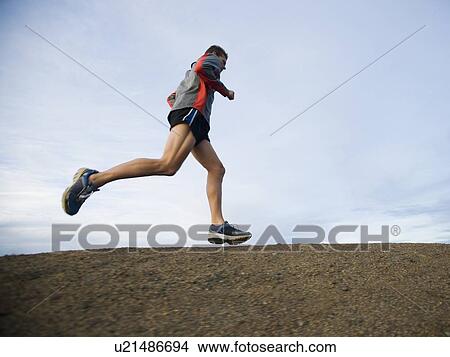 Picture - Person running on trail. Fotosearch