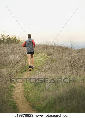 Stock Image - Person running on trail. Fotosearch