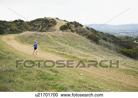 Stock Image - Person running on trail. Fotosearch