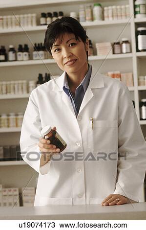 Pharmacist holding a bottle of prescription medication View Large Photo Image Stock Image - Pharmacist holding a bottle of prescription medication. Fotosearch