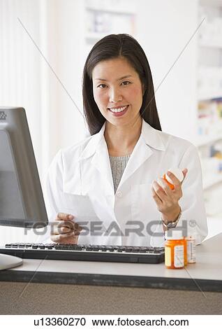 Pharmacist holding prescription medication View Large Photo Image Stock Image - Pharmacist holding prescription medication. Fotosearch